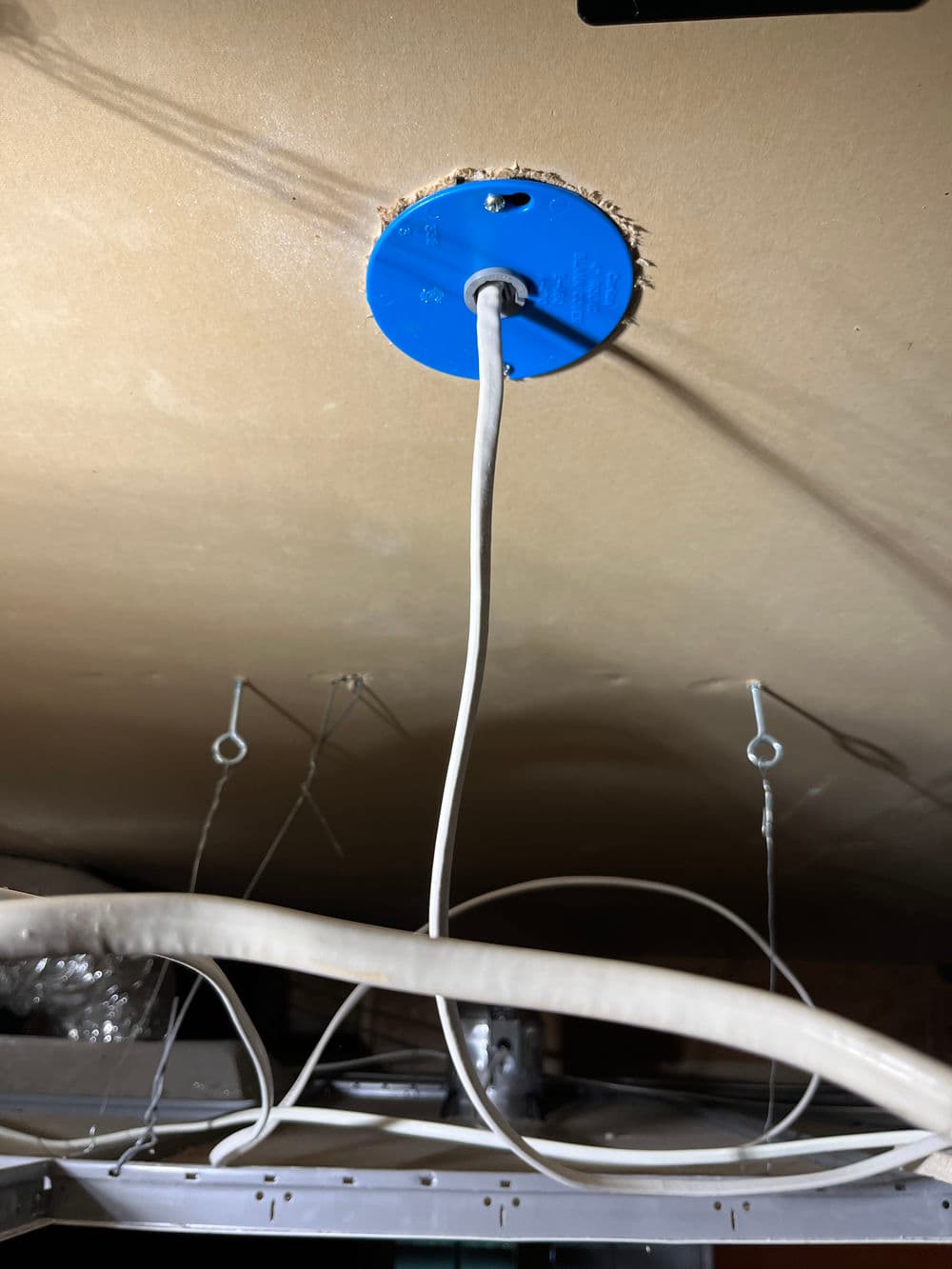 Electrical junction box with hanging wires and ceiling structure visible. Ideal for lighting installation.